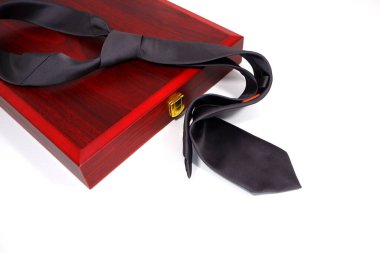 Düz kumaştan siyah kravat beyaz arka plan yakın görüşlü ahşap kutunun üzerine serilmiş. 