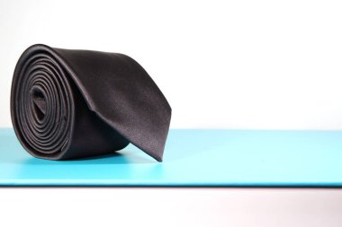 Düz kumaştan siyah kravat beyaz arkaplan görünümünde tek bir nesne üzerinde yuvarlandı 