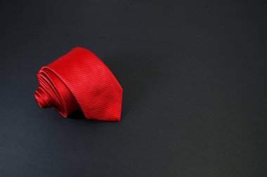 Siyah arkaplanda kırmızı bir kravat takıldı. Yakın plan görüntüsü tek bir nesne 