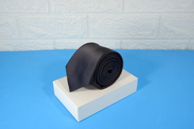 Beyaz duvar arkaplan yakın görünümü olan bir siyah kravat ekran kutusuna takıldı 