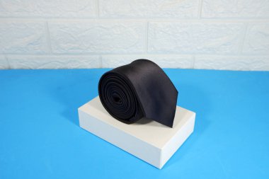 Beyaz duvar arkaplan yakın görünümü olan bir siyah kravat ekran kutusuna takıldı 