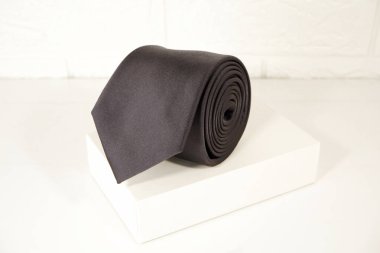 Beyaz arkaplan görünümlü siyah bir kravat ekran kutusuna sarılmış. 