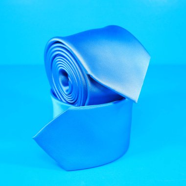 Düz kumaş polyester kravatlar mavi arkaplan yakın görüntüsü ile eşleşir 