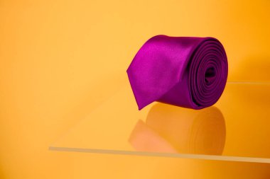 Mor renkli polyester kumaş kravat. Rafta sarılı. Yakın çekim. 