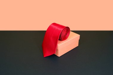 Kırmızı kravat renk arkaplanlı hediye kutusuna takıldı 