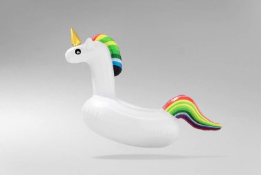 Yaratıcı sanat asgari estetik. Işık arka planda şişme tek boynuzlu at havuz oyuncağı. Asgari yaz konsepti