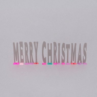 Renkli ahşap harflerden ve keskin gölgelerden yapılmış ışık arkaplanlı yaratıcı Merry Noel ağacı süslemesi. En az yeni yıl partisi konsepti. Düz yatıyordu.