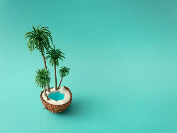 Coconut tropical island with palm leaves and swimming pool on blue background. Tropical beach concept made of coconut fruit and palm trees . Creative minimal summer idea.