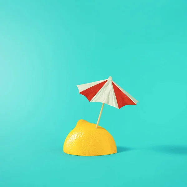 Tropical beach concept made of lemon and sun umbrella. Summer creative art. Minimal citrus fruits aesthetic.