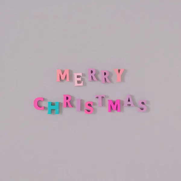 Yaratıcı Merry Noel ağacı süslemesi. Renkli ahşap harflerden yapılmış hafif bir arka planı var. En az yeni yıl partisi konsepti. Düz yatıyordu.