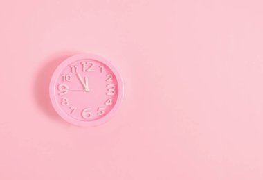Pembe boyalı duvardaki pembe çalar saat. Asgari zaman kavramı. Noel arifesi ya da yeni yıl fikri