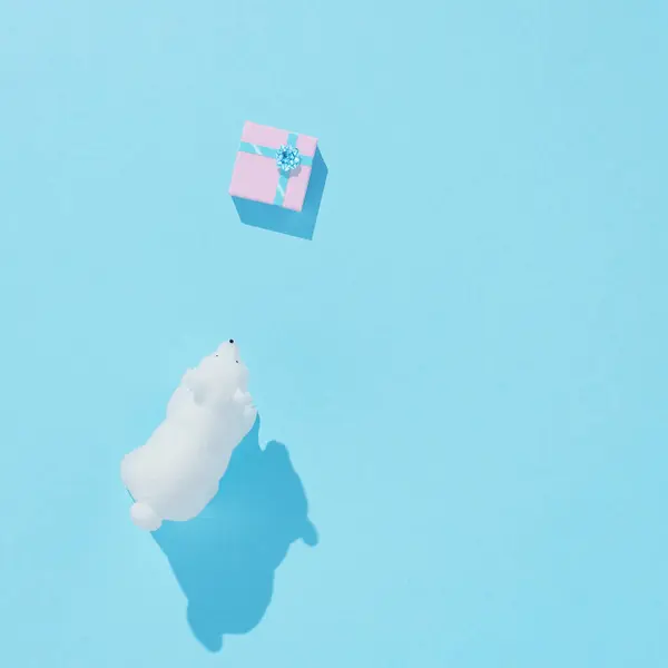 Kutup ayısı oyuncak Noel hediye kutusu parlak pastel mavi arka plan ile. Noel ve kış tatil kavramı.