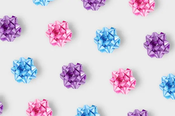 最小的构图背景为塑料紫色 蓝色和粉色装饰圣诞礼品弓 新年概念 — 图库照片