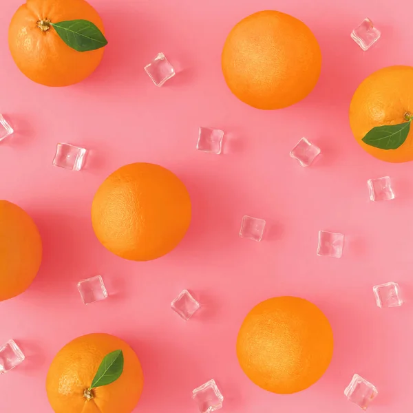 Portakal ve buz küpleri canlı pembe bir arka plan üzerinde yaratıcı yaz desen yaptı. Meyve en az kavramı.