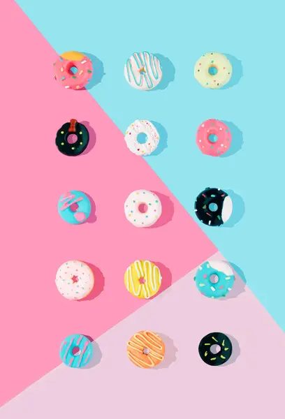 彩色甜甜圈在淡蓝色和粉色背景上的创意图案 最小食物的概念 等距测量 — 图库照片