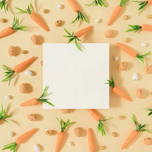 Paskalya deseni havuç ve paskalya yumurtalarından yapılmış parlak pastel sarısı arka planda. Yaratıcı minimum Paskalya bayramı konsepti bahar bayramı kutlaması ya da fikri. Düz uzanış Yazma alanı