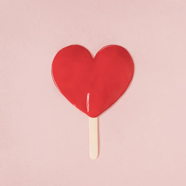 スティックに溶けたアイスクリームのシルエットで心臓の形をした赤いペイント ミニマルバレンタインまたは愛のコンセプト フラットレイ — ストック写真