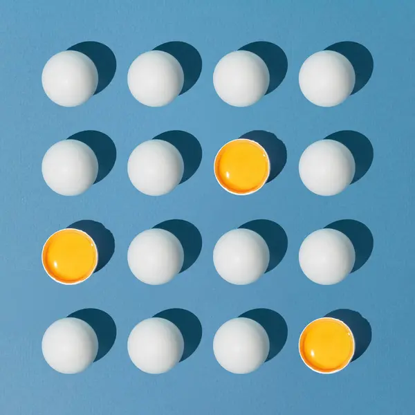 Mavi arka planda yumurtadan yapılmış yaratıcı bir kompozisyon. Minimum doğu konsepti. Yaratıcı sanat, asgari estetik. Düz yatıyordu.