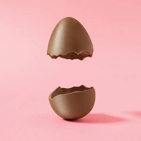 Tvůrčí Skladba Čokoládovým Velikonočním Vejcem Rozpůlená Pastelově Růžovém Pozadí Kreativním — Stock fotografie