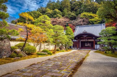 Manzaralı bir taş patika Japonya 'nın Kyoto kentindeki tapınak alanındaki bir binaya açılıyor.