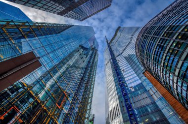 Modern cam ve çelik yapılar, kentsel yenilenmeden geçmiş bir şehirde birbirlerini yansıtıyorlar.