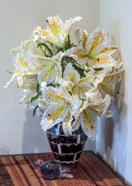 Japon zambakları, liyum auratum, ya da altın işlemeli zambak, Japon seramik vazosunun içine konmuş kırmızı kahverengi benekli sarı şeritlere sahiptir.