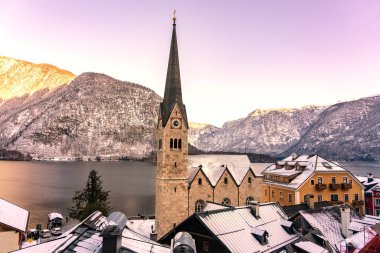 Avusturya 'daki özel şehrin güzel şehir manzarası Salzkammergut karlı kış dağları, göl ve gün batımında kilise. .