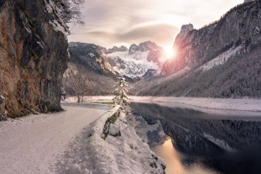 Beautiful snowy winter landscape with Dachstein mountain and Gosausee in Austria near Hallstatt sunset