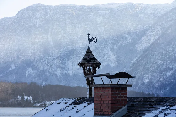 Rustic chimney on a rooftop in Hallstatt with a rooster