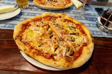 Hırvatistan 'da bir deniz ürünleri restoranında deniz ürünleri frutti di mare pizza yemek. .