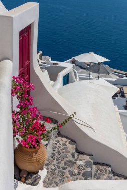 Oia Santorini 'nin dikey renkli manzarası. Kapı süslemesinin yanında çiçek var. .