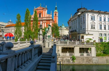 09.08.2021: Ljubljana, Slovenya: Tromostovje köprüsü ve Ljubljanica nehri üzerindeki Cerkev Marijinega oznanjenja kilisesi .