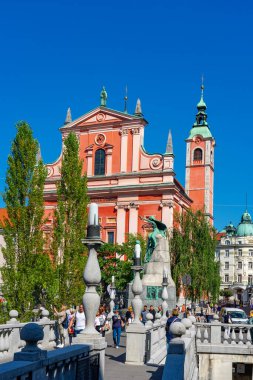 09.08.2021: Ljubljana, Slovenya: Tromostovje köprüsü ve Ljubljanica nehri üzerindeki Cerkev Marijinega oznanjenja kilisesi .