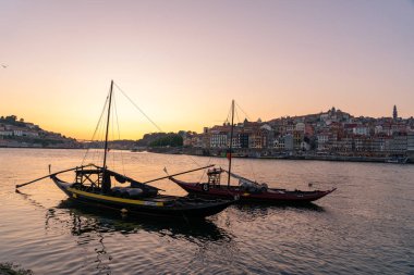 Akşam Porto 'da ufuk çizgisi Duero Nehri' nin nehir kıyısında gün batımında iki tekneyle. .