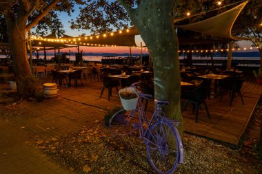 Balatonlelle 'deki Balaton Gölü' nde güzel dekore edilmiş açık hava masaları. .