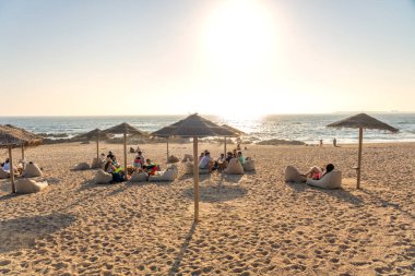 06.22.2023. Porto, Portekiz: Porto Portekiz sahilinde güneş gözlüklü şık bir bar ve günbatımının tadını çıkaran insanlar. .