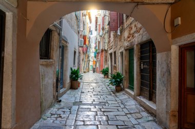 Rovinj Hırvatistan 'ın güzel caddesi, kaldırım taşlarıyla bir kemer tünelinden bakıyor. .