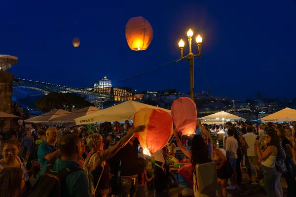 06.23.2023. Porto, Portekiz: Festa de Sao Joao do Porto Sokakta akşamları uçan fenerlerle mutlu insanlar .