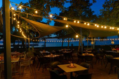 Balatonlelle 'deki Balaton Gölü' nde güzel dekore edilmiş açık hava masaları. .