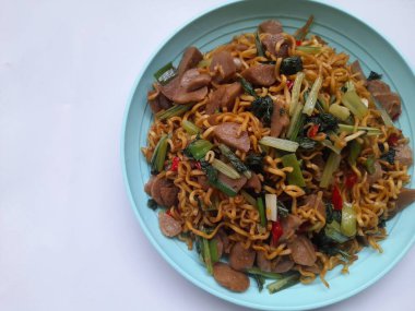 Kızarmış şehriye (mie goreng) beyaz arka planda bir tabak üstünde. Kahvaltı, öğle yemeği, akşam yemeği, fast food, yaşam tarzı, mutfak, mutfak, yemek, atıştırma, yemek tarifi