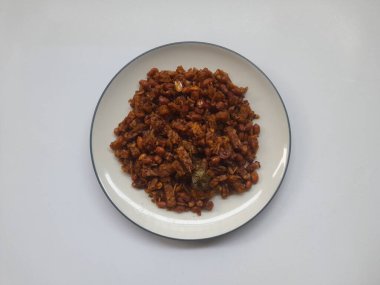 Kızarmış Tempe Orek yiyecekleri beyaz arka planda üst tabakta. Sağlıklı gıda geçmişi, yemek tarifi, kahvaltı, öğle yemeği, akşam yemeği, yemek, yemek, yemek, yemek, yemek, ev yapımı yemek.