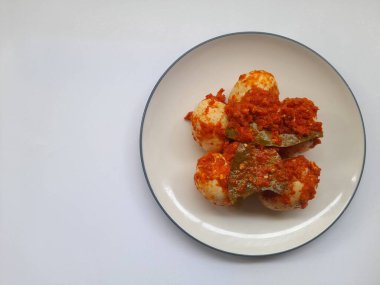 Bembeyaz arka planda tabak üzerinde kırmızı biber soslu yumurta kaynatılmış. sağlıklı gıda geçmişi, yemek tarifi, kahvaltı, öğle yemeği, akşam yemeği, yemek, yemek, yemek, yemek, yemek, mutfak, malzeme