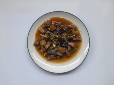 Beyaz arka planda üst tabakta kızarmış sığır derisi (kikil) karıştırılmış yiyecek. Kolesterol gıda geçmişi, abur cubur, yemek tarifi, kolesterol, ev yapımı, restoran, yemek pişirme, öğle yemeği.