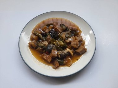 Beyaz arka planda üst tabakta kızarmış sığır derisi (kikil) karıştırılmış yiyecek. Kolesterol gıda geçmişi, abur cubur, yemek tarifi, kolesterol, ev yapımı, restoran, yemek pişirme, öğle yemeği.