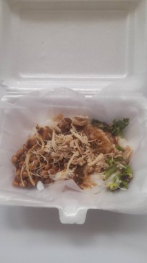 Beyaz arka planda köpüklü tavuklu yulaf lapası (bubur ayam) yiyeceği. Sağlıklı yemek, yemek tarifleri, kahvaltı, yaşam tarzı, yemek, yemek, yemek, yemek, yemek, yemek, gurme, restoran, gelenek