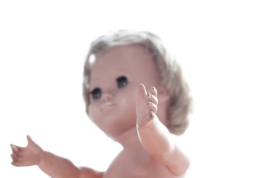 Sarışın ve boyalı gözlü antika bir bebeğin yakın çekimi. Klasik 20. yüzyıl ortası oyuncağı nostaljiyi, çocukluk anılarını ve antika tasarımı simgeliyor..