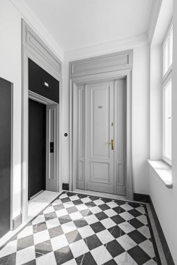 Klasik tarzda merdiven. Tahta elementli çelik korkuluk. Dairenin büyük gri ön kapısı. Asansörlü geniş koridor.