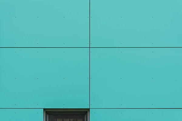 Colorful facade of the object, building. Material of vertical turquoise panels.
