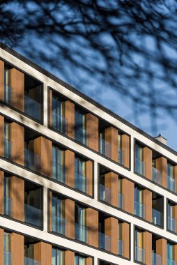 Şehir merkezindeki modern çoklu aile binasının detayları. Çok sayıda kat var. Balkonlar ve loggialar. Güneşli hava