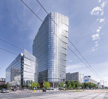 Gökdelen, gökdelen, ofis binası. Güneşli bulutsuz hava. Harmony, düz çizgiler. Şehir trafiği, kavşak